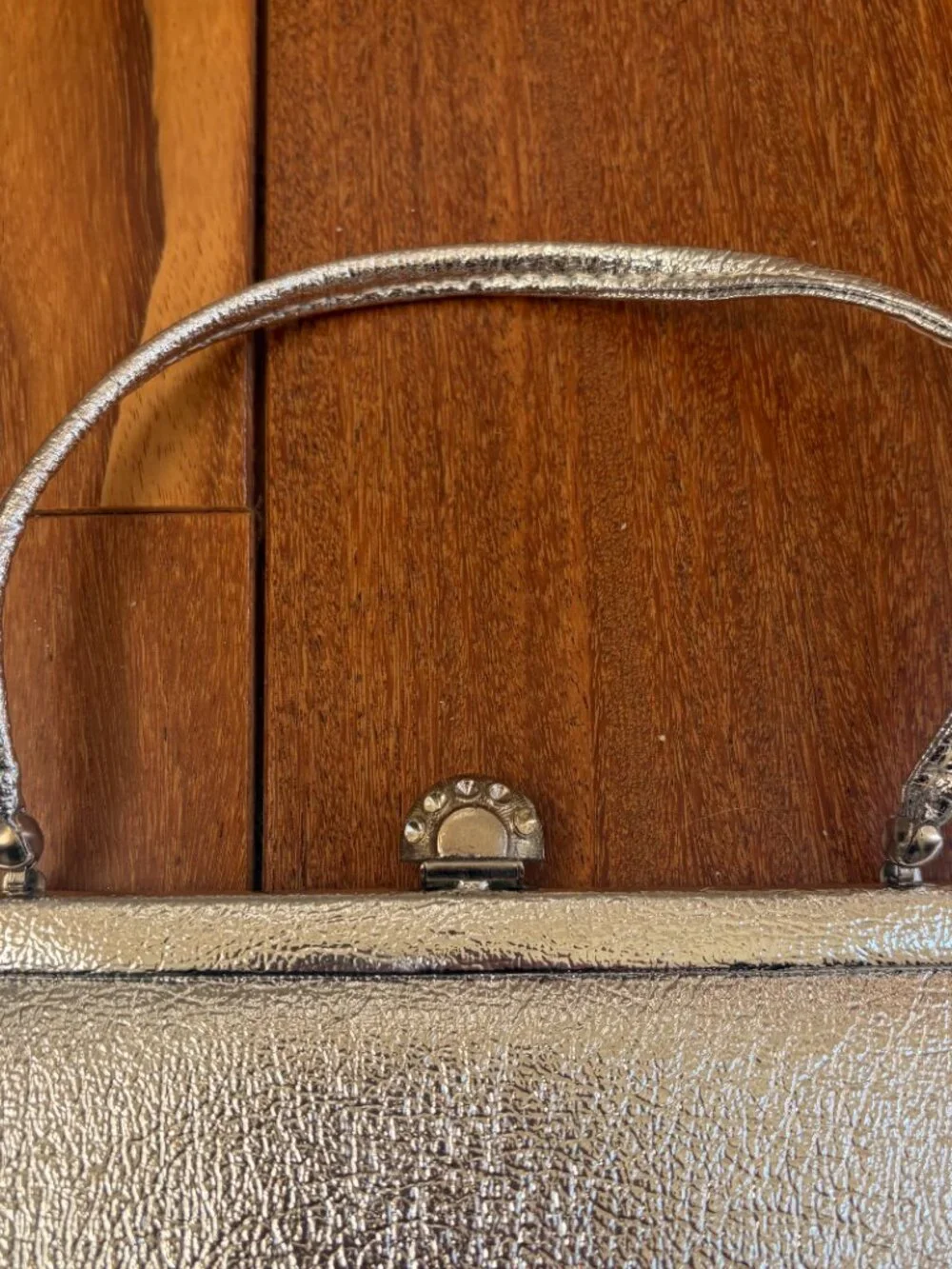 Silver vintage metallic evening clutch with a kiss lock closure and thin strap